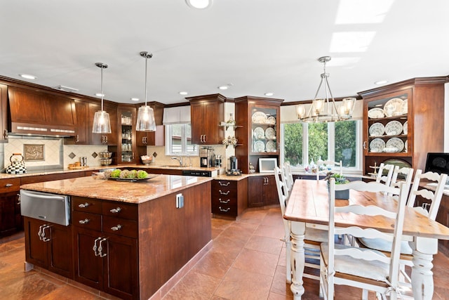 kitchen with tasteful backsplash, recessed lighting, a warming drawer, a sink, and a notable chandelier