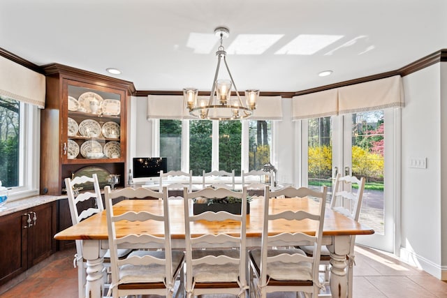 dining area featuring crown molding, french doors, a wealth of natural light, and a chandelier