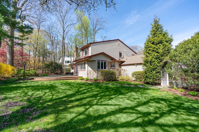 back of property with a lawn and a chimney