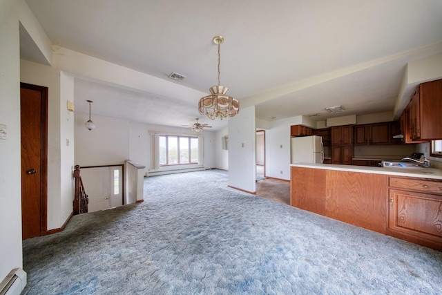 kitchen with light colored carpet, freestanding refrigerator, a peninsula, open floor plan, and visible vents