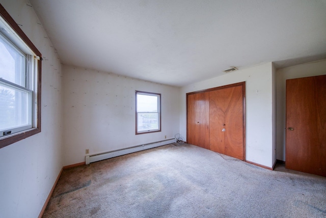 unfurnished bedroom featuring a closet, visible vents, baseboards, baseboard heating, and carpet