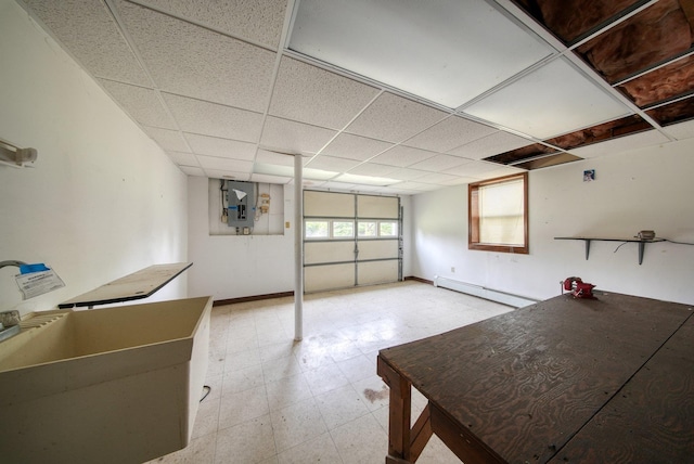 garage featuring baseboards, baseboard heating, and electric panel