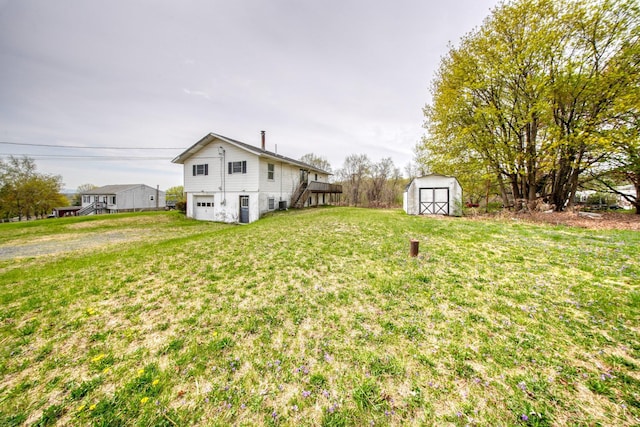 view of yard with stairway, a garage, an outdoor structure, and a storage unit