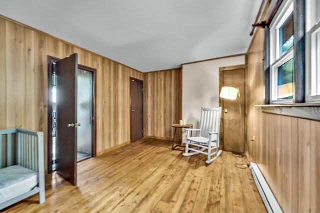 85 Woodard Rd, Parksville, NY 12768 - living area with wooden walls, a baseboard heating unit, and light wood-style floors