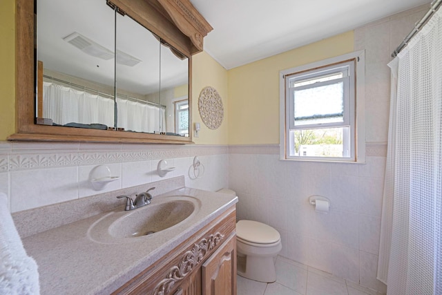 7 Hedge Ln, Centereach, NY 11720 - full bath featuring tile walls, tile patterned floors, a wainscoted wall, vanity, and toilet