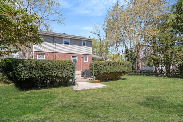 7 Hedge Ln, Centereach, NY 11720 - back of house featuring a yard, brick siding, and a patio