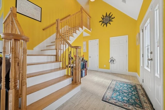 10 Delta Rd, Massapequa, NY 11758 - entryway with high vaulted ceiling, stairway, baseboards, healthy amount of natural light, and wood finished floors