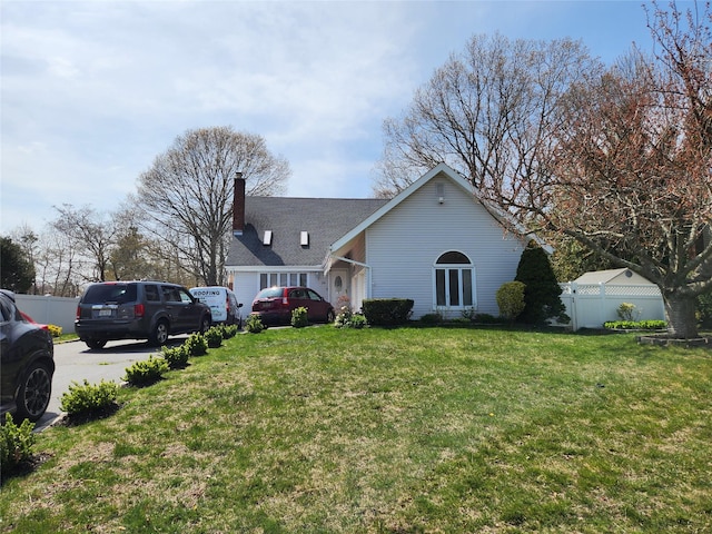 view of property exterior with fence, a lawn, and a chimney