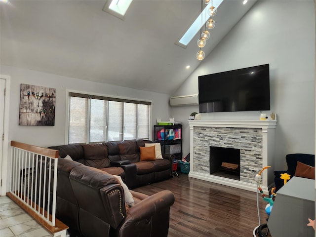 living room with wood finished floors, an AC wall unit, a skylight, a fireplace, and high vaulted ceiling