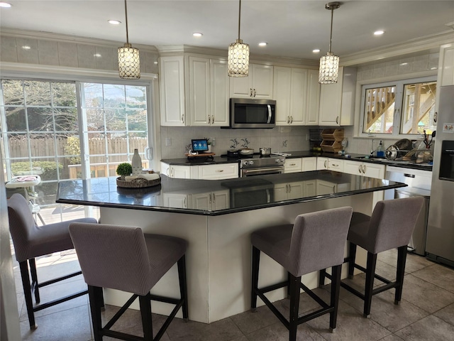 kitchen featuring backsplash, dark countertops, white cabinetry, and stainless steel appliances