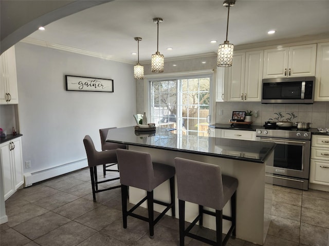 kitchen featuring stainless steel appliances, a breakfast bar, dark countertops, a baseboard heating unit, and decorative backsplash