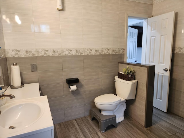 bathroom featuring tile walls, toilet, and vanity