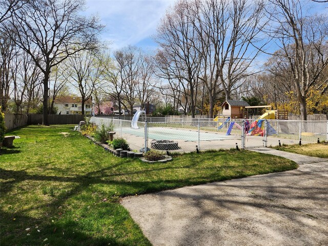 view of yard with an outdoor structure, a playground, and fence