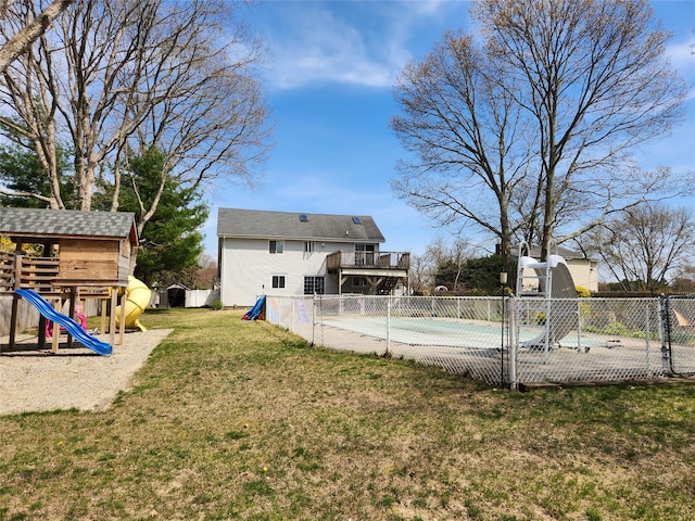 view of swimming pool with a covered pool, fence, a yard, and a playground