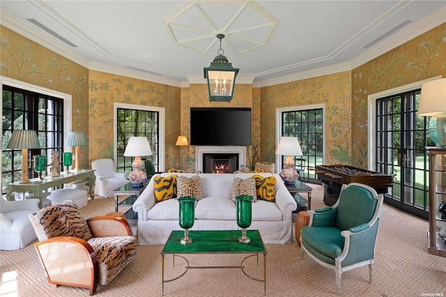 carpeted living area featuring crown molding, wallpapered walls, and a warm lit fireplace