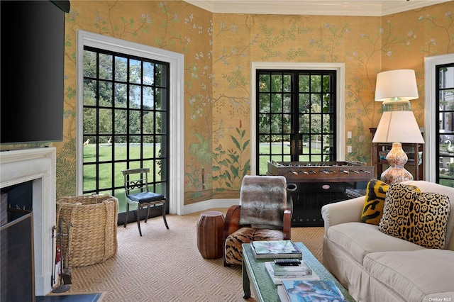 living room featuring crown molding, baseboards, carpet, and wallpapered walls