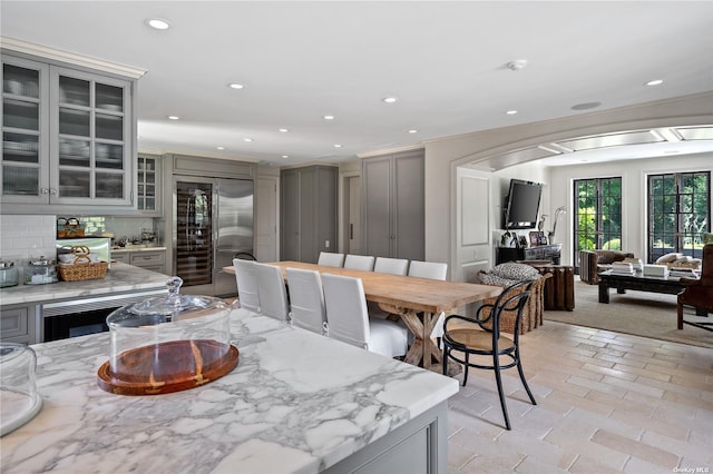 dining area with crown molding, recessed lighting, and arched walkways