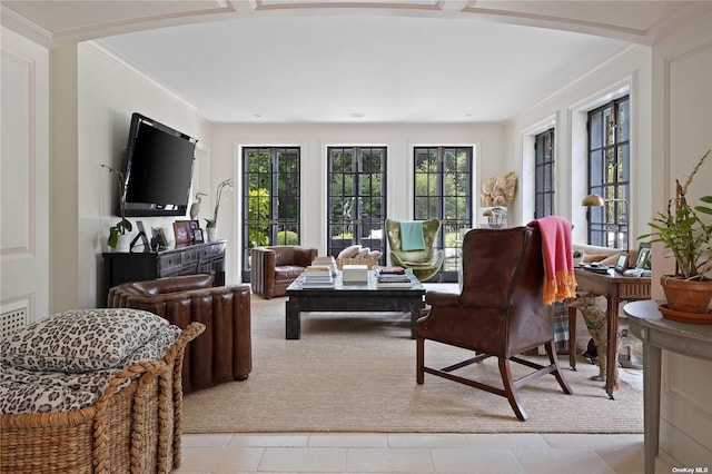 living area featuring crown molding, arched walkways, and light carpet