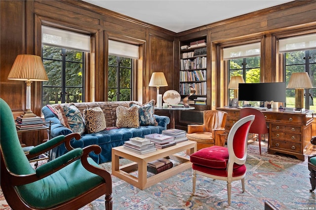 sitting room featuring wood walls and built in shelves