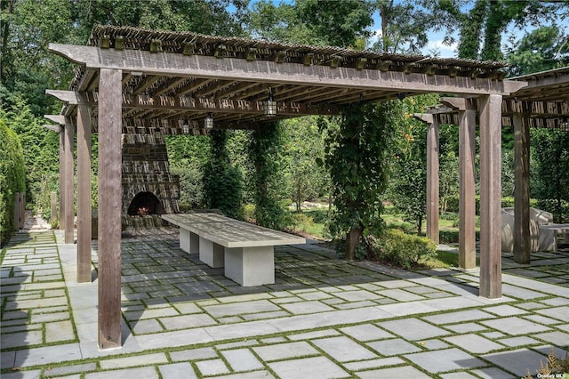 view of patio / terrace with a pergola and a warm lit fireplace