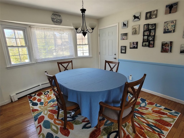 dining area featuring hardwood / wood-style floors, a wealth of natural light, and a baseboard radiator