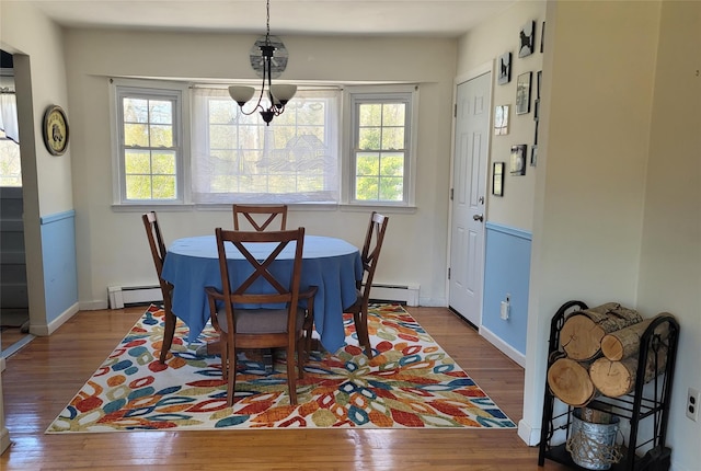 dining room with baseboard heating, baseboards, and hardwood / wood-style floors