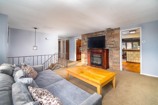 carpeted living area featuring visible vents and a stone fireplace