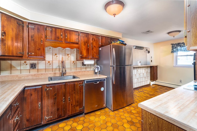 kitchen with tasteful backsplash, a baseboard radiator, appliances with stainless steel finishes, a sink, and visible vents