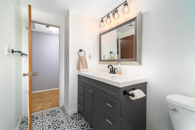 bathroom featuring toilet, vanity, and baseboards