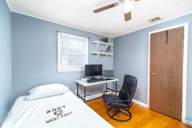 bedroom featuring visible vents, wood finished floors, crown molding, and a baseboard radiator
