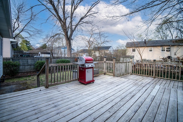 wooden terrace featuring grilling area and a fenced backyard