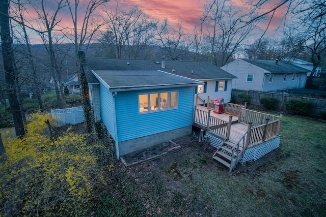 back of house with a deck, fence, a chimney, and roof with shingles