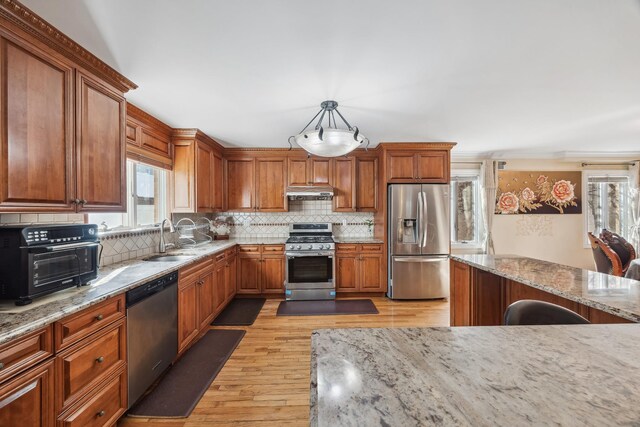 154-60 Riverside Dr, Whitestone, NY 11357 - kitchen featuring under cabinet range hood, a sink, light wood-style floors, decorative backsplash, and appliances with stainless steel finishes