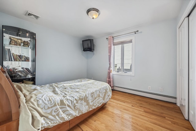 154-60 Riverside Dr, Whitestone, NY 11357 - bedroom featuring wood finished floors, baseboard heating, visible vents, and a closet