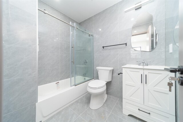 3405 Corporal Kennedy St, Bayside, NY 11361 - full bathroom with vanity, toilet, tile walls, tile patterned floors, and enclosed tub / shower combo