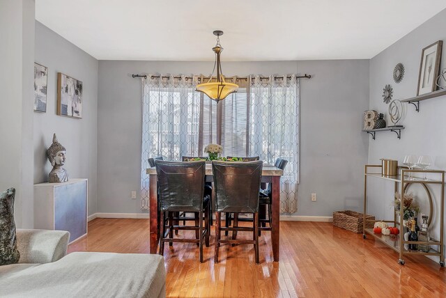 dining area featuring light wood-style flooring and baseboards