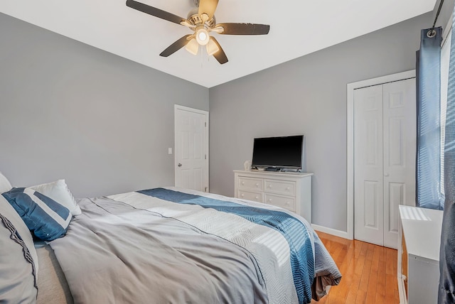 bedroom featuring light wood-type flooring, a closet, baseboards, and ceiling fan
