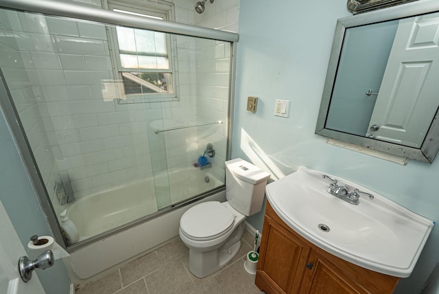 bathroom featuring tile patterned flooring, toilet, bath / shower combo with glass door, and vanity