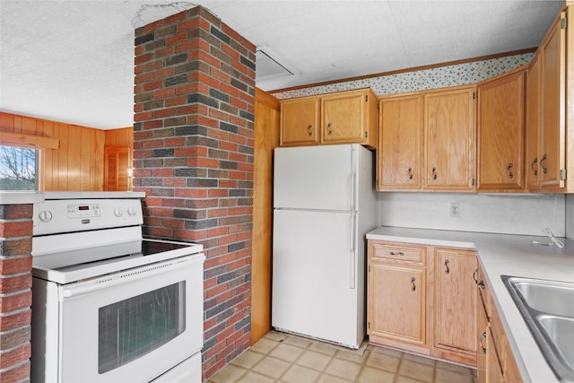 kitchen featuring light floors, a sink, white appliances, and light countertops