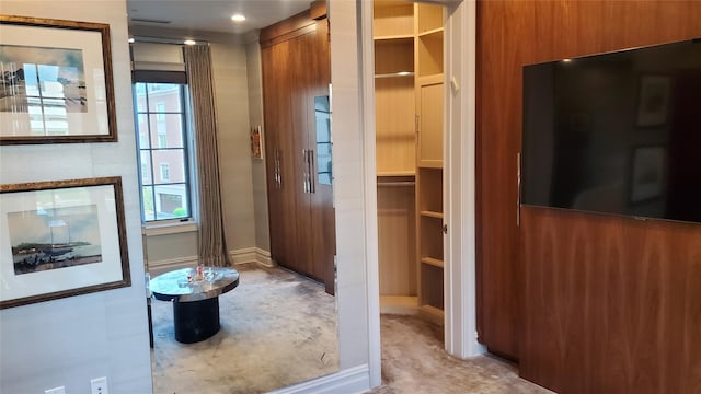 corridor featuring baseboards and light carpet