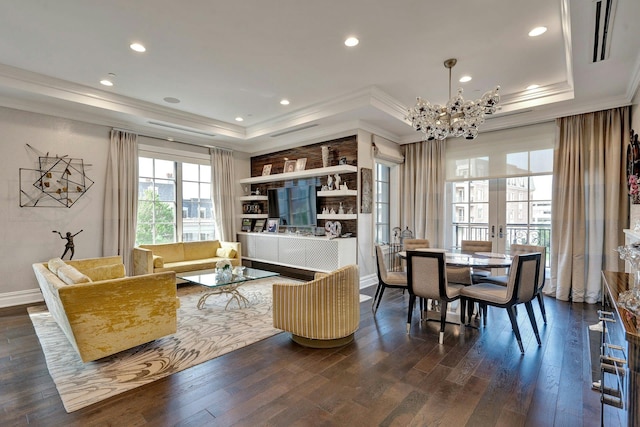 living area with a tray ceiling, crown molding, healthy amount of natural light, dark wood-style floors, and a chandelier