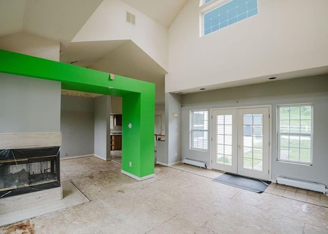 7 Cornwell St, Poughquag, NY 12570 - unfurnished living room featuring baseboard heating, plenty of natural light, high vaulted ceiling, a baseboard heating unit, and french doors