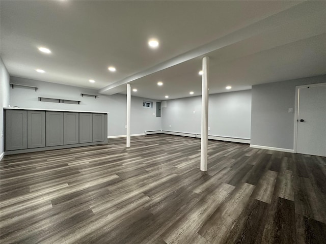finished basement featuring baseboards, baseboard heating, dark wood-style floors, and recessed lighting