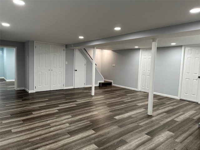 finished basement featuring recessed lighting, dark wood-type flooring, stairway, and baseboards