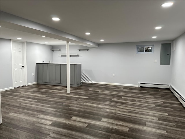 finished below grade area featuring a baseboard heating unit, dark wood-style flooring, and recessed lighting