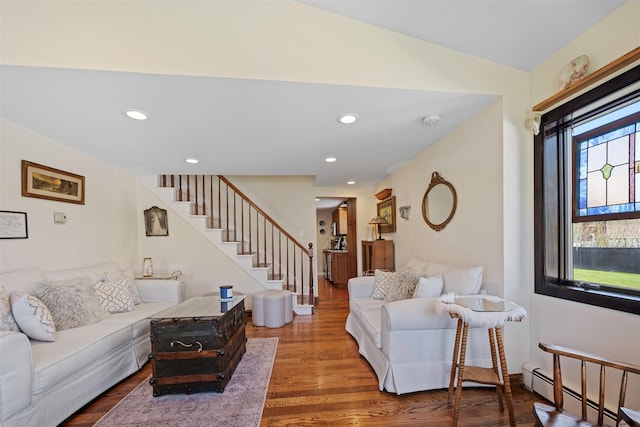 living area with recessed lighting, wood finished floors, stairs, and a baseboard radiator