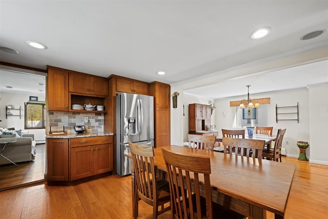 dining area featuring an inviting chandelier, ornamental molding, recessed lighting, and light wood finished floors