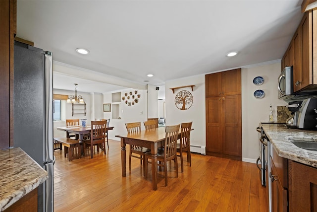 dining room featuring baseboard heating, recessed lighting, ornamental molding, and light wood-style flooring