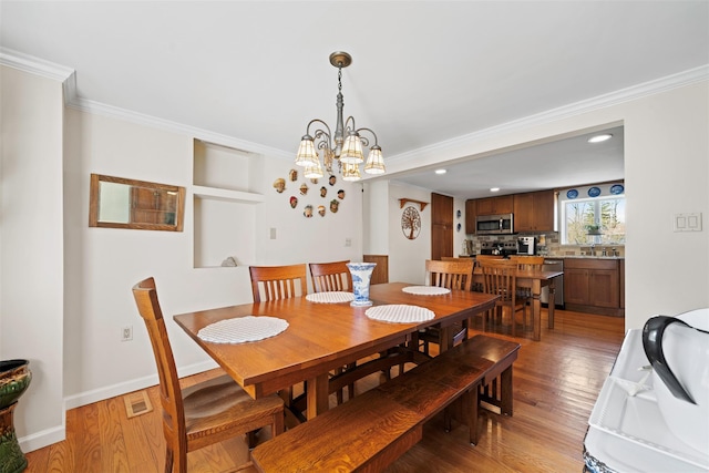 dining area featuring crown molding, visible vents, light wood-style floors, recessed lighting, and a notable chandelier
