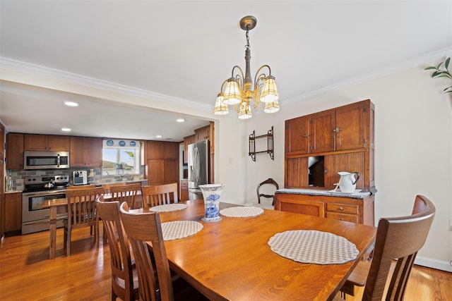 dining room with light wood-style flooring, recessed lighting, a notable chandelier, and crown molding
